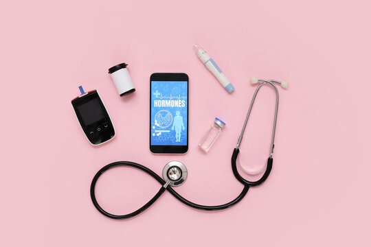 Mobile phone with glucometer, lancet pen and stethoscope on pink background. Endocrinology concept