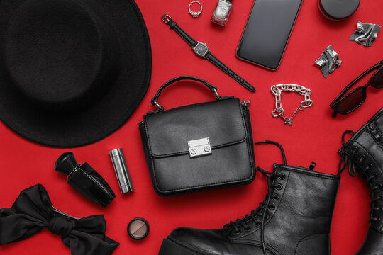 Composition with shoes, black hat, cosmetics and accessories on red background. Closeup