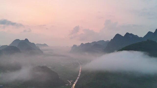 Dusk Over Karst Mountains, Orange Sunset Glow, Mist in Valleys, Country Road with Traffic Lights 
