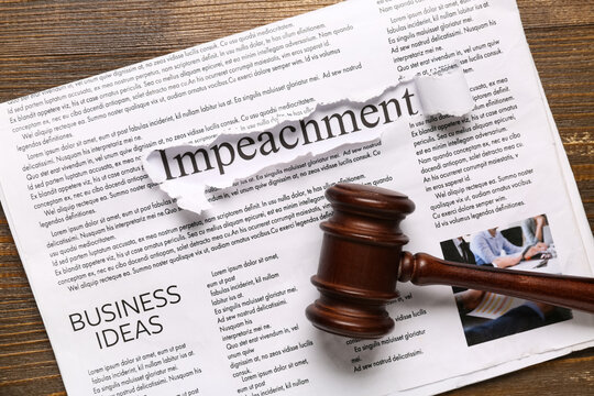 Newspapers with word IMPEACHMENT and judge gavel on wooden background