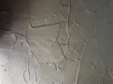 Close-up texture of a rough concrete wall with visible trowel marks, imperfections, and a raw, industrial loft style surface. concrete wall texture