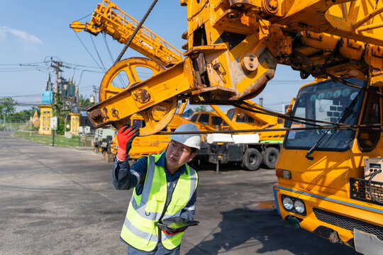 Construction inspector examining crane machinery at industrial site