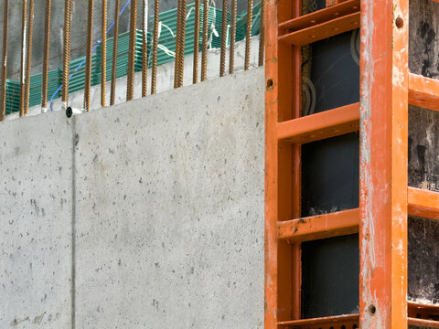 View of a concrete wall with orange metal formwork and steel rebar at a construction site in Sariyer, Istanbul, Turkiye.