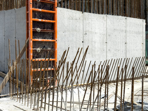 View of a concrete wall with orange formwork and vertical steel rebar at a construction site in Sariyer, Istanbul, Turkiye.