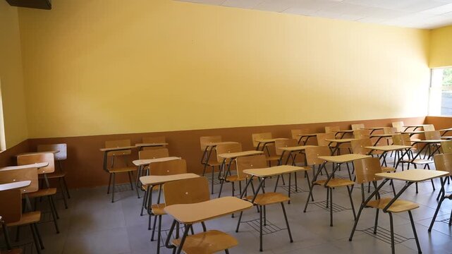 Interior footage of a modern classroom featuring organized student desks, academic atmosphere, and educational infrastructure inside a school campus.