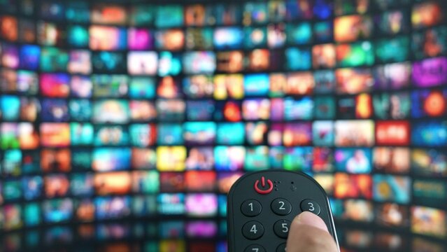 A remote in hand, navigating endless entertainment on a giant TV reflects the ease of modern content selection, home theater experiences, technological advancement, and the joy of streaming media.
