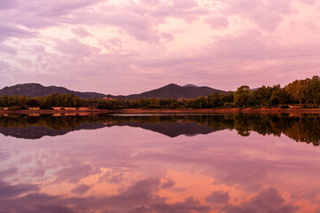 Obraz premium S'Ena e Sa Chitta coastline with calm sea at sunset. Reflections of sky on water. Sardinia, Italy, Mediterranean landscape.