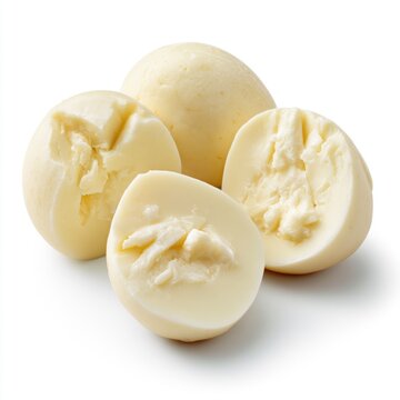 Four pieces of smooth, creamy white cheese balls, two whole and two cut in half, showcasing their soft texture inside.