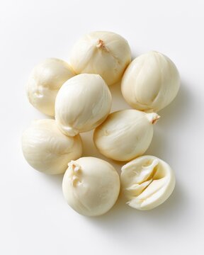 Fresh white mozzarella balls arranged on a white surface, showcasing smooth texture and mild shine.