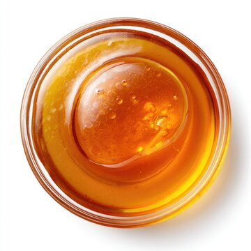 A close-up top view of a glass bowl filled with golden honey, showing its smooth, viscous texture and tiny air bubbles.