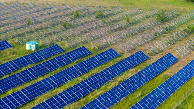 Newly installed solar panels in a renewable energy field, view of racked solar panels in a field, installing new power needed to generate energy from the sun.