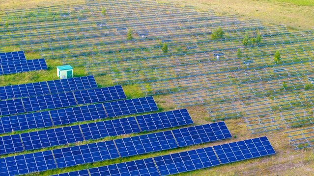Newly installed solar panels in a renewable energy field, view of racked solar panels in a field, installing new power needed to generate energy from the sun.