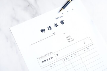 御請求書 - 取引先へ宛てて請求書を準備する、ビジネスシーンのイメージ  © PJM