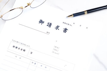 御請求書 - 取引先へ宛てて請求書を準備する、ビジネスシーンのイメージ  © PJM