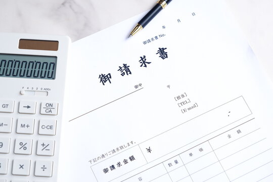 御請求書 - 取引先へ宛てて請求書を準備する、ビジネスシーンのイメージ

