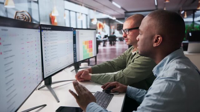 Enterprise Risk Managers Analyze Financial Data On Computer