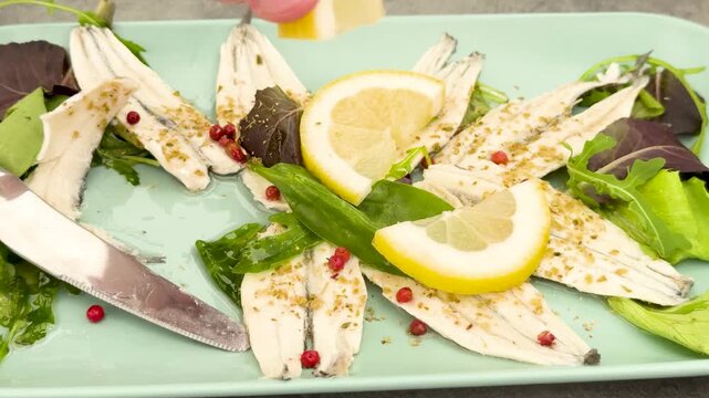 Squeezing Fresh Lemon Juice Over Marinated Anchovy Fillets Appetizer