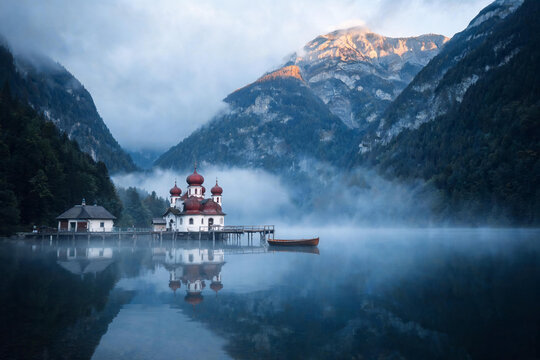 St bartholomew's church konigssee reflecting in misty mountain lake