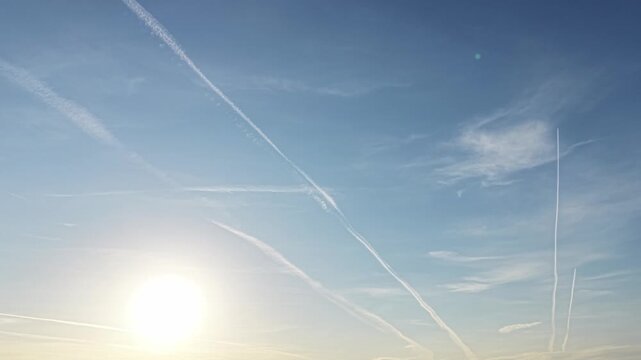 Bright open sky with dissolving aviation contrails