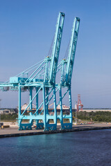 Obraz premium view usa cargo ship terminal, Unloading crane of cargo ship terminal, Aerial view industrial port with containers and container ship.