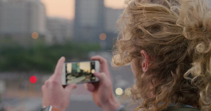 Travel, photo or man in town with phone screen, sightseeing memory or outdoor post on weekend break. Wind, back or person with tech, social media update or city skyline picture on tourist trip.