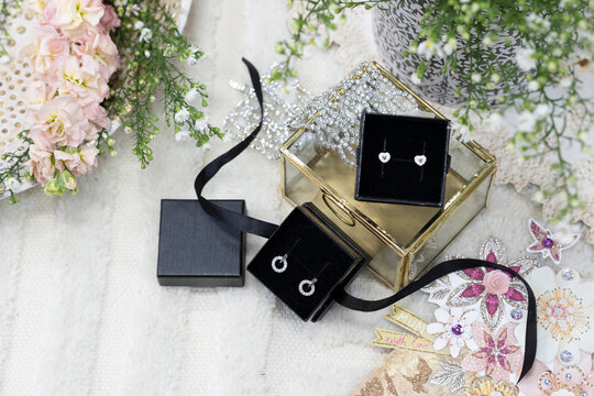 Mother's Day jewellery gift display with earrings flowers and luxury gift boxes