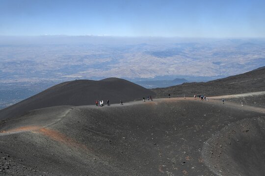 Hikers in the crater landscape of the volcano Etna, summit region, province of Catania, Sicily, Italy