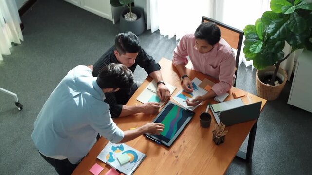 Top view of skilled business team discuss about marketing strategy while manager explain financial plan. Male leader standing and presenting idea while investor listening presentation. Convocation.