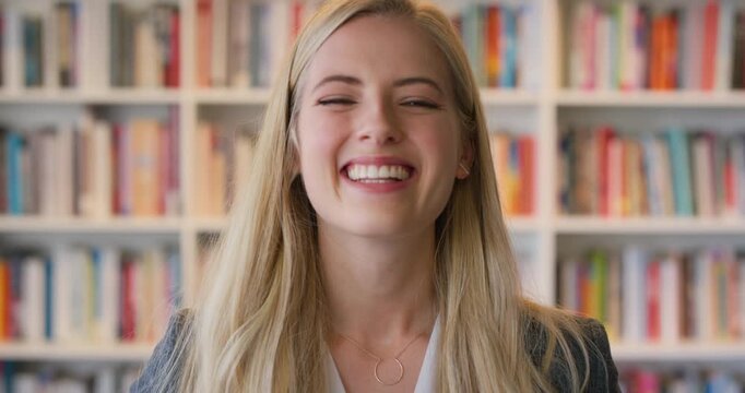 Woman, face and education for student with laugh at college, bookshelf or confident at campus library. Girl, happy and portrait for learning, academic research or project at university in Australia