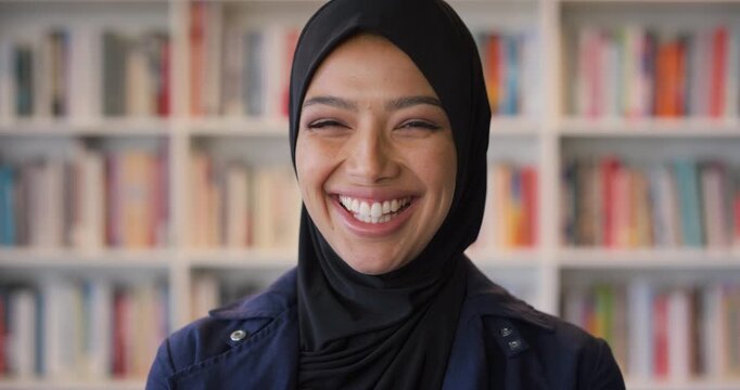 Smile, confidence and face of muslim woman in library for university, education or studying with knowledge. Hijab, portrait and islamic student in college for learning, pride and campus scholarship