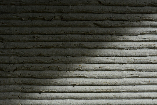 Close-up texture of corrugated cardboard paper with parallel lines and subtle shadow