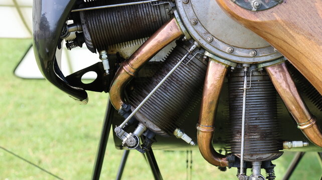 View of a vintage radial aircraft engine with cooling fins, copper pipes and a wooden propeller hub in La Ferte-Alais, Ile-de-France, France.