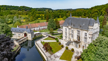 Fototapeta premium Aerial drone view of historic Schaloen castle surrounded by water moat, green gardens and beautiful nature landscape, Limburg, the Netherlands