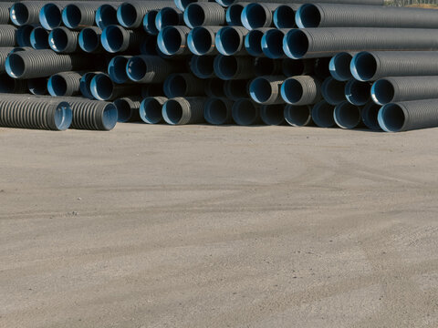 View of stacked black corrugated plastic pipes with blue interiors on a construction site Sariyer, Istanbul, Turkiye.