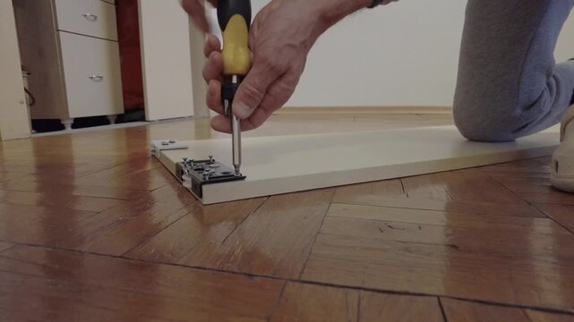 Specialist calibrates machinery for smooth flooring operation. Expert technician carefully calibrates and aligns roller assembly ensuring smooth movement on wooden flooring