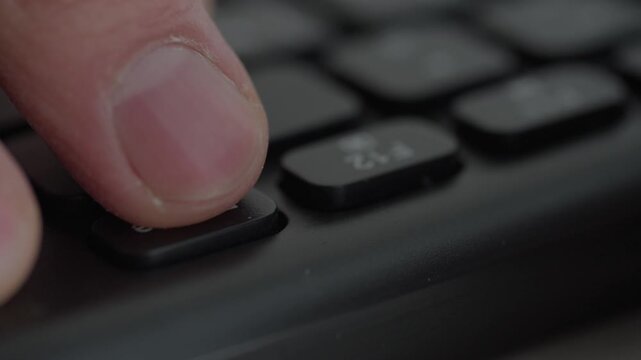 Closeup finger pressing delete key, monitor flashes red and warning light pulses as office admin accidentally erases files, tense atmosphere, dim workspace, urgent data loss