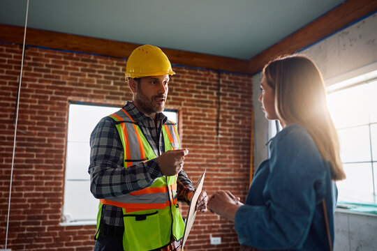 Building contractor communicating with woman during home improvement project.