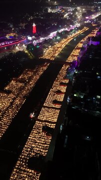 Ayodhya, India - 30 October 2024: Aerial view of millions of oil lamps illuminating the riverbank during Deepotsav festival at night.