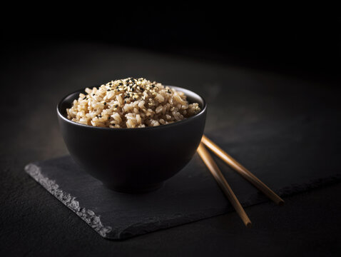 Healthy brown rice served in a minimalist bowl with chopsticks, creating a clean and modern food concept. Perfect for wellness campaigns, menus, packaging and social media content.