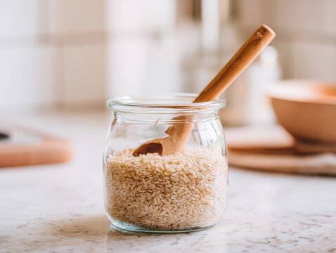 Organic rice stored in a glass container with minimalist kitchen styling and soft natural light. Perfect for nutrition content, recipe websites, banners and marketing materials.