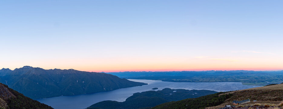 Breathtaking sunset panorama of Lake Te Anau from the Kepler Track, New Zealand. Features vibrant pastel twilight skies and expansive copy space, ideal for travel web banners and hero images.