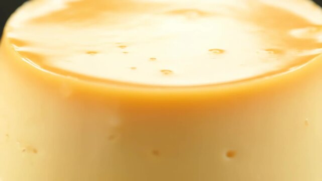 Extreme macro close-up of smooth golden caramel custard pudding or flan dessert showing glossy texture and perfect surface
