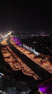 Ayodhya, India - 30 October 2024: Aerial view of thousands of oil lamps illuminating the riverbank and ghats during the Deepotsav festival celebration at night.