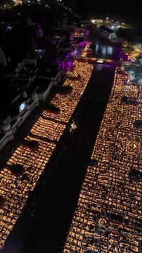 Ayodhya, India - 30 October 2024: Aerial view of thousands of oil lamps arranged in patterns along the river ghats during the Deepotsav festival at night.