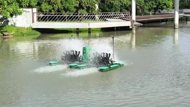 A paddlewheel aerator floating on the water, splashing water into the air to increase oxygen levels.
