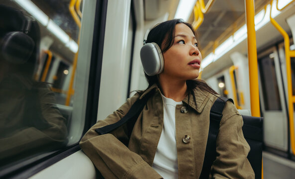 Woman listening on train with headphones during commute