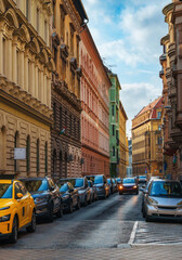 Obraz premium Beautiful street view with classic historic architecture and parked cars on a sunny day in Budapest Hungary urban city scene background