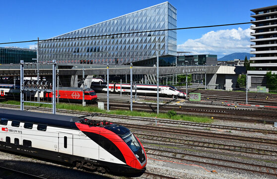 Geneva, Switzerland, Europe - 05.2026 : Stadler KISS and bullet Stadler SMILE - Swiss electric unit trains and SBB Re 460 four-axle electric locomotive, headquarters of Japan Tobacco International