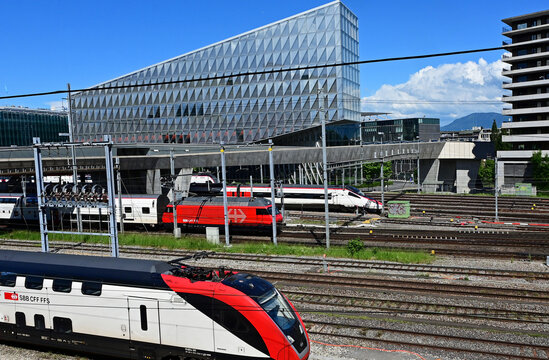 Geneva, Switzerland, Europe - 05.2026 : Stadler KISS and bullet Stadler SMILE - Swiss electric unit trains and SBB Re 460 four-axle electric locomotive, headquarters of Japan Tobacco International