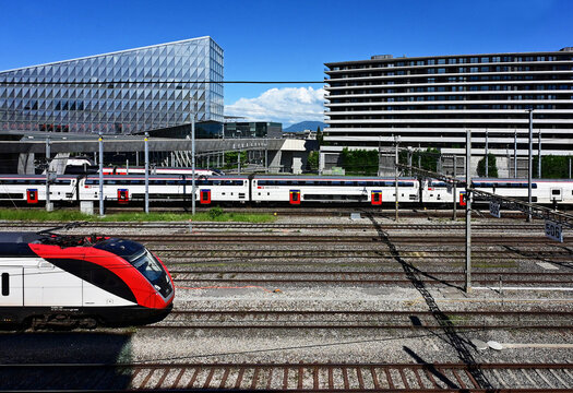 Geneva, Switzerland, Europe - 05.2026 : Swiss rolling stock, in front Stadler KISS - electric multiple unit train, JTI - headquarters of Japan Tobacco International, Picciotto students house at right